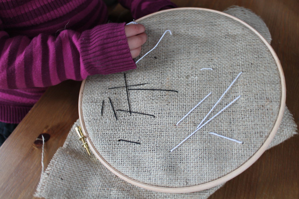 child embroidering burlap