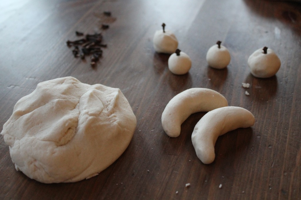 a lump of salt dough apples with cloves as stalks and bananas made from salt dough