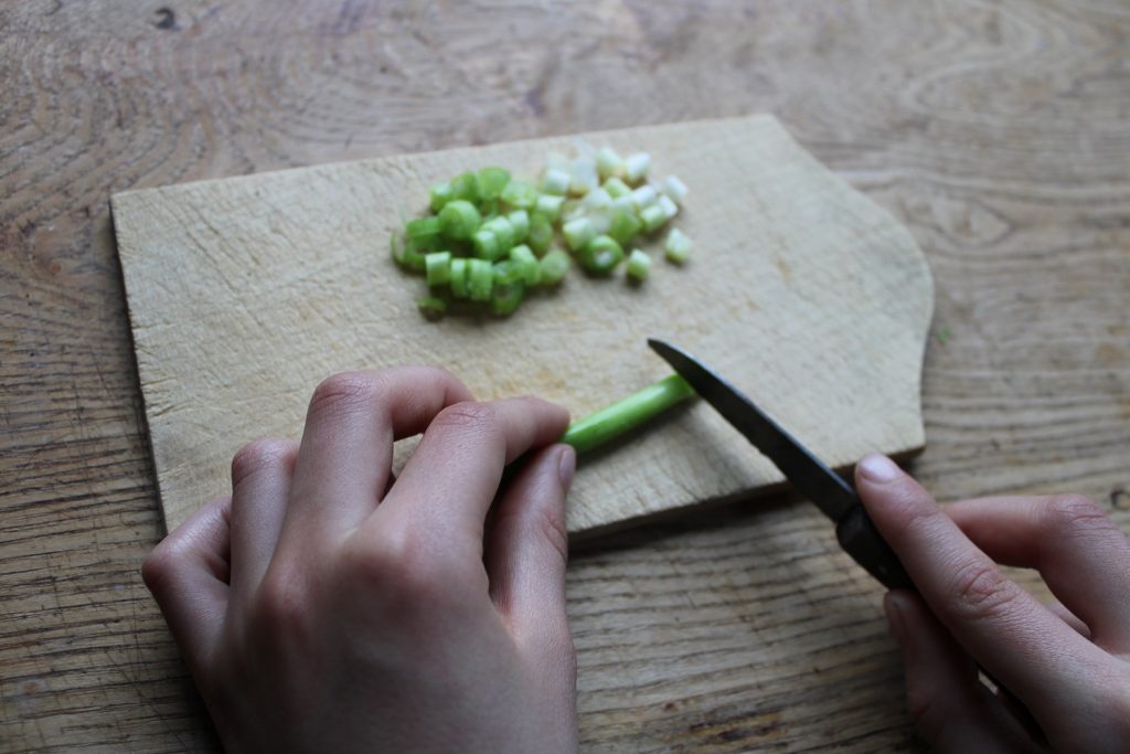 childs hands chopping spring onions - how to make cream cheese