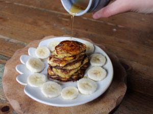 maple syrup pouring over baby banana pancakes