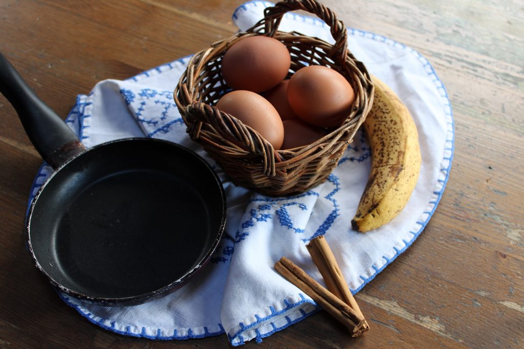 free range eggs banana pan and cinnamon stick on cloth