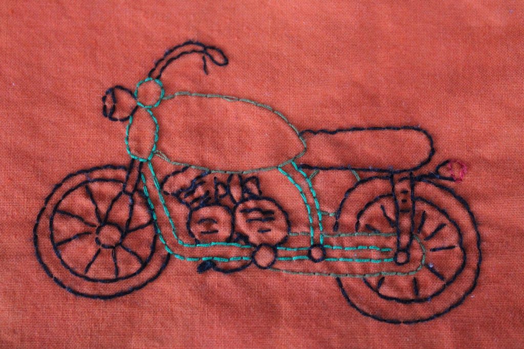 embroidered motorbike on orange cotton
