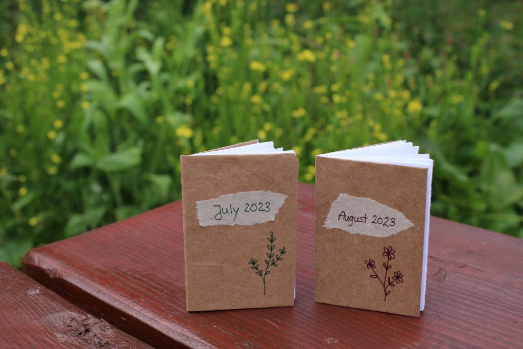 two handmade mini journals on an outdoor table