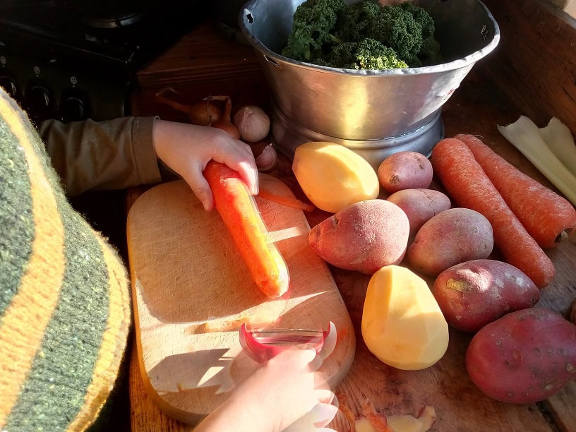 child peeling a carrot
